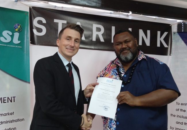 TCSI Commissioner Calvin Ziru (right) handing over the signed and sealed license to Ryan Goodnight