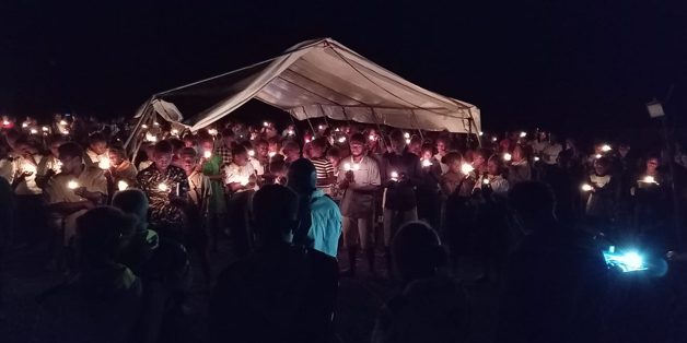 Young youths light their candles and make promises to shines to others in their communities. Photo by Harry Samuel