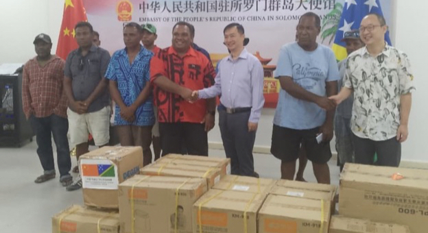 Ambassador Cai Weiming (fifth from left in front row) shaking hands with the MP for East Makira Derek Wasi during the handing over.