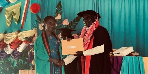 Dr John Lenga Sisiolo presents one of the graduating F6 students with her certificate of accomplishment. Photo by Michael Koti