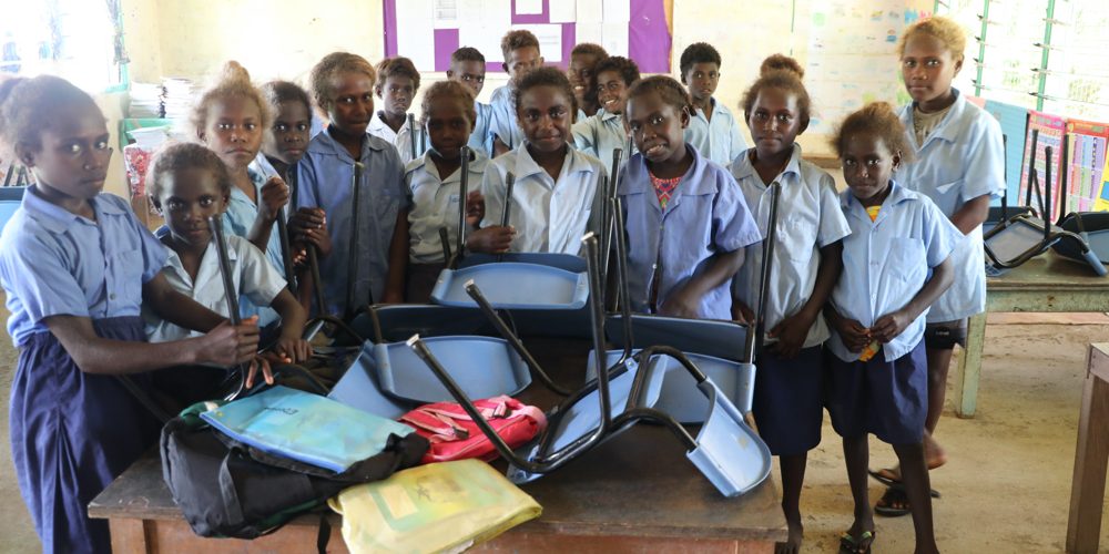 Year 2 students standing behind their donated chairs with excitement on October 15, 2024. Photo Gane A Simbe