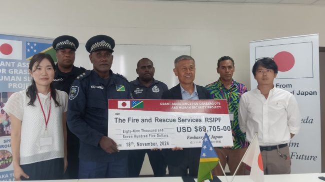 Ambassador Miwa and RSIPF Fire Service Supervising Director Mr Ketaru holding the ceremonial cheque for the fire trucks. With them are Japanese Embassy and RSIPF Fire Service officials