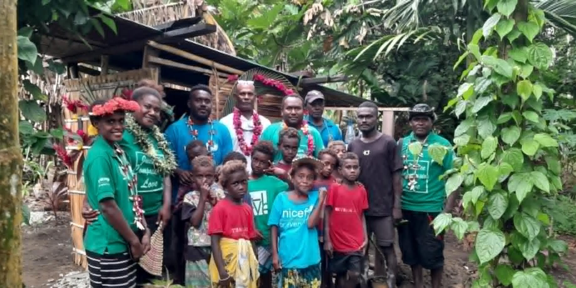 ADRA Staff,Community and Mr Ronald Bula at back with hat take photo infront of his sanitation project