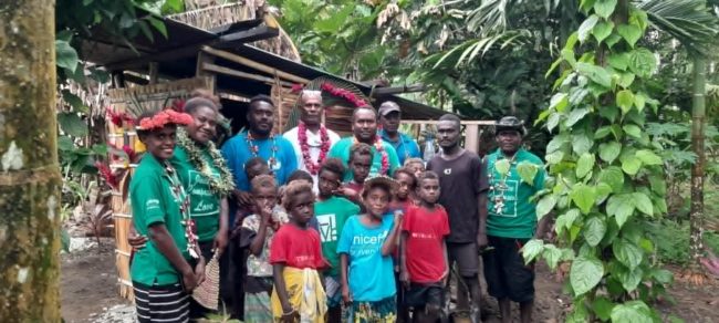 ADRA Staff,Community and Mr Ronald Bula at back with hat take photo infront of his sanitation project