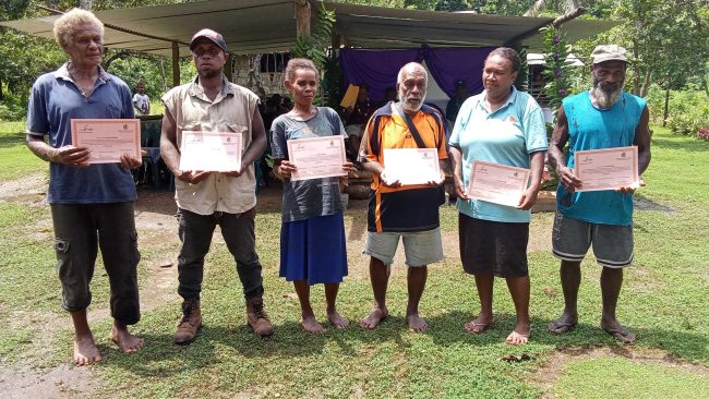 Representatives of communities receiving their NOD status certificates pose for a group photo