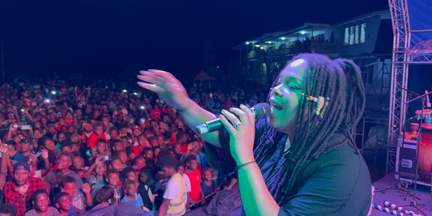 Christafari’s assistant lead vocalist, Avion Claudette Trudy Henrietta, plays the guitar during a show in Auki