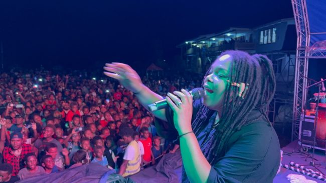 Christafari’s assistant lead vocalist, Avion Claudette Trudy Henrietta, plays the guitar during a show in Auki