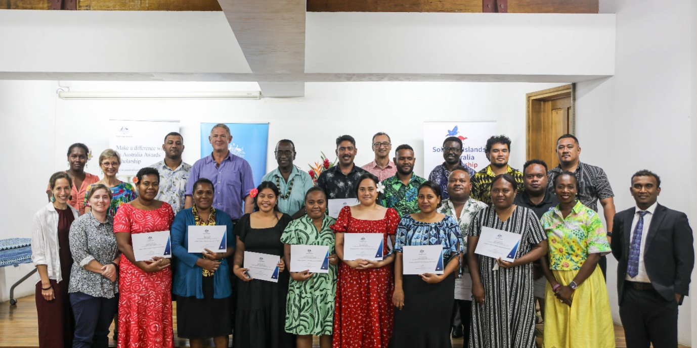 Group photo of the fourteen graduates and officials at the awards ceremony.